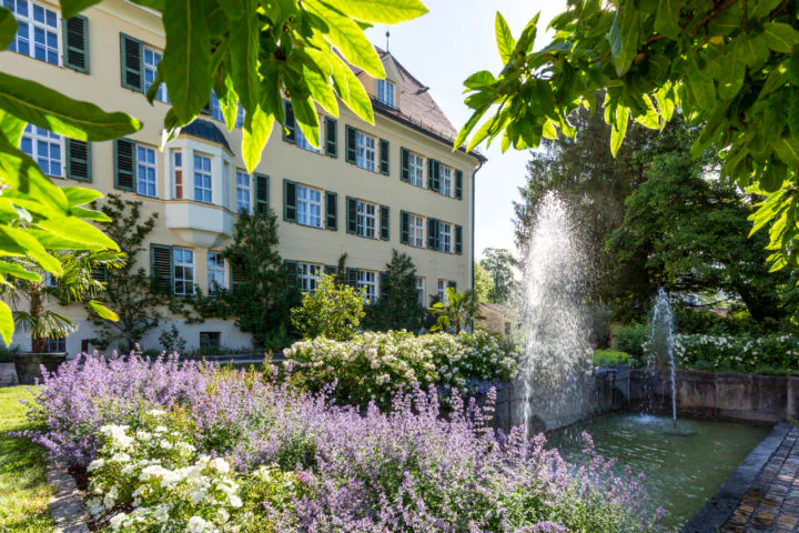 Springbrunnen und Staudenbeet vor dem Haupthaus