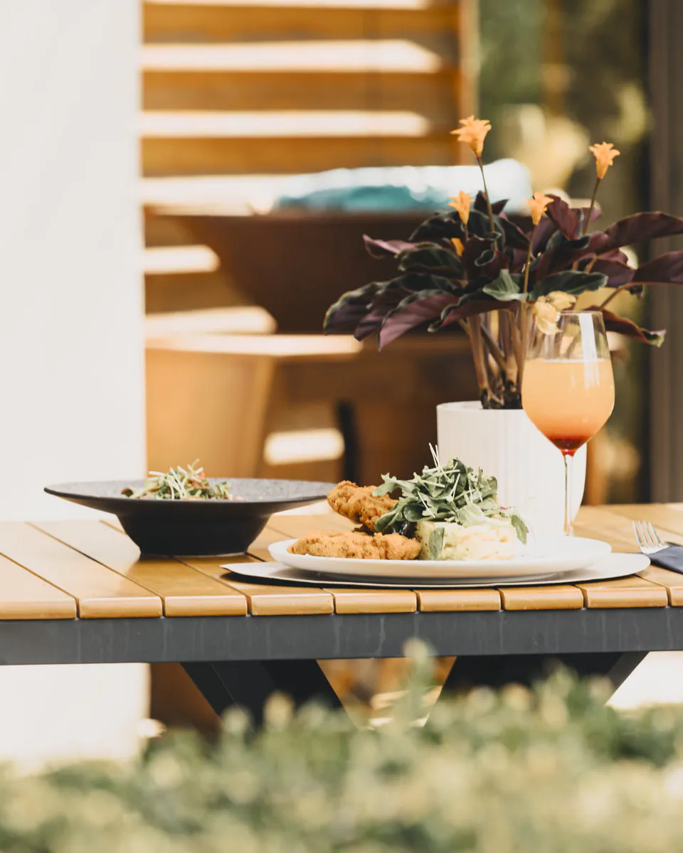 Gedeckter Tisch mit Schnitzel, Salat und Aperitif